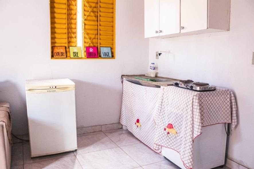 Cozinha do chalé com frigobar, bancada, cooktop e armário